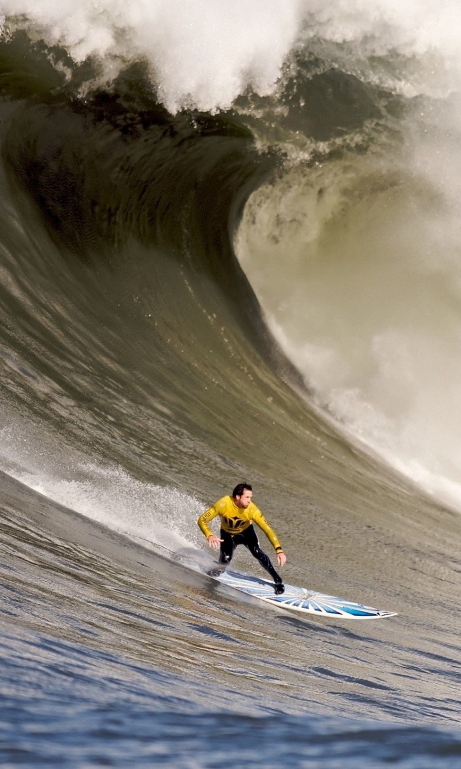 Surfeur en combinaison de bain jaune chevauchant une grande vague dans l'océan (océan, sport, surf, surfing, eau)