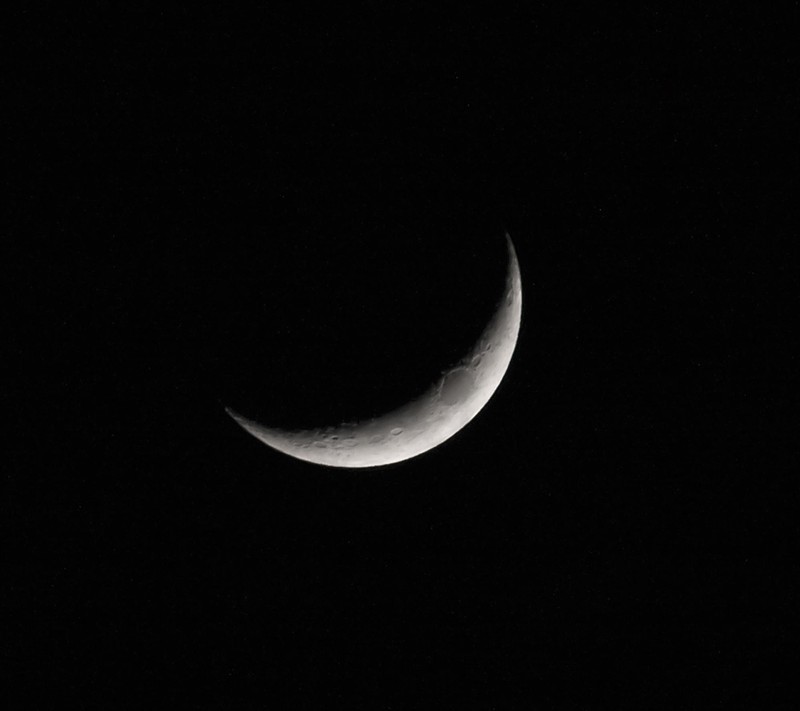 Nahaufnahme eines halbmondes am dunklen himmel mit einem vorbeifliegenden flugzeug (schwarz, halfmoon)