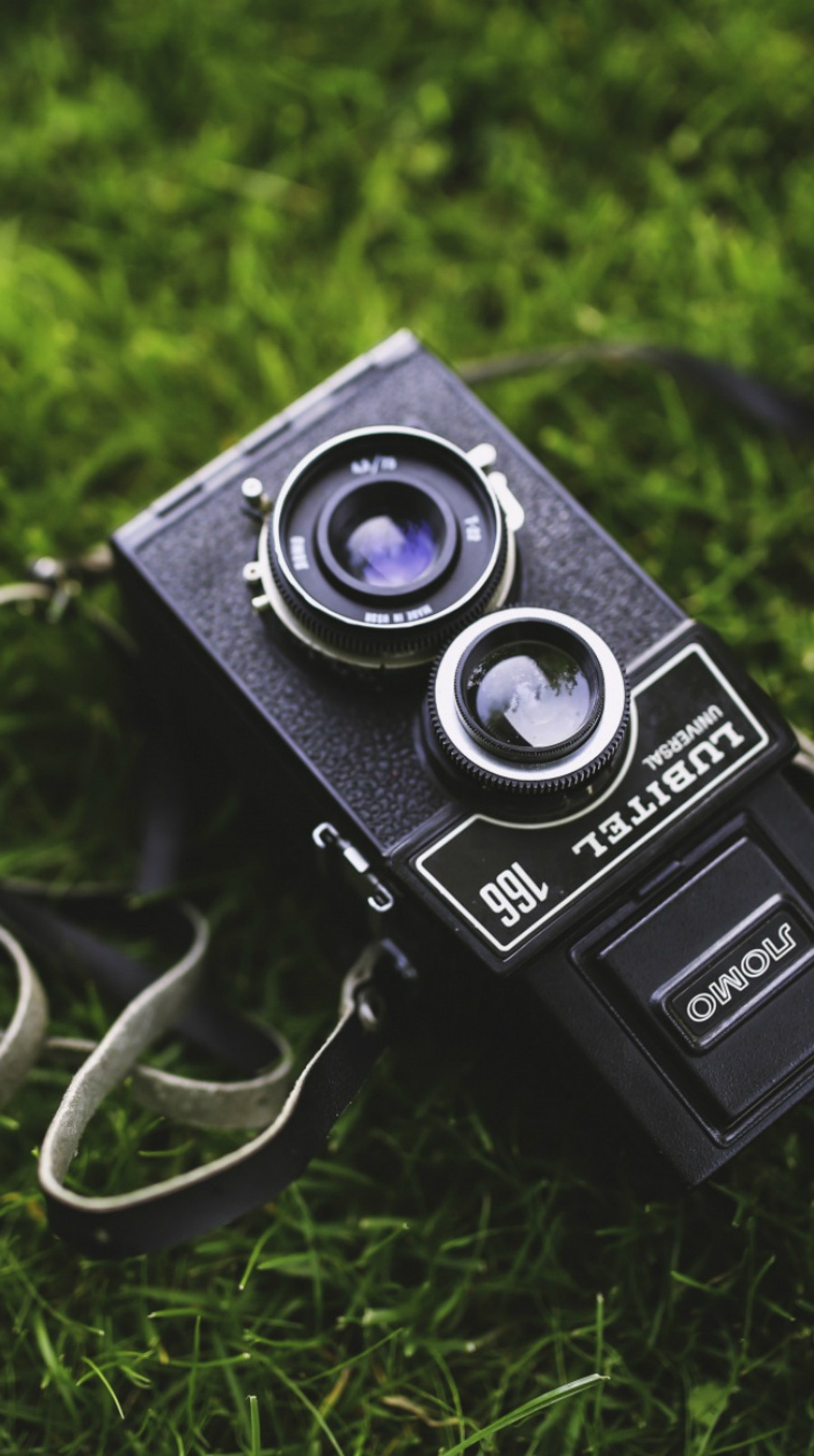 There is a camera that is sitting on the grass (camera, grass, lubitel, old)