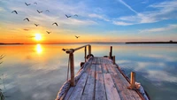 Dusk Serenity: A Wooden Pier Overlooking a Tranquil Lake at Sunset