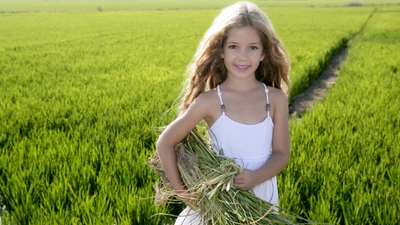 Chica cosechando cultivos en un exuberante campo de arroz