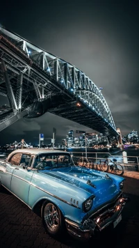 Klassischer Chevrolet unter einer Stadtbrücke bei Nacht