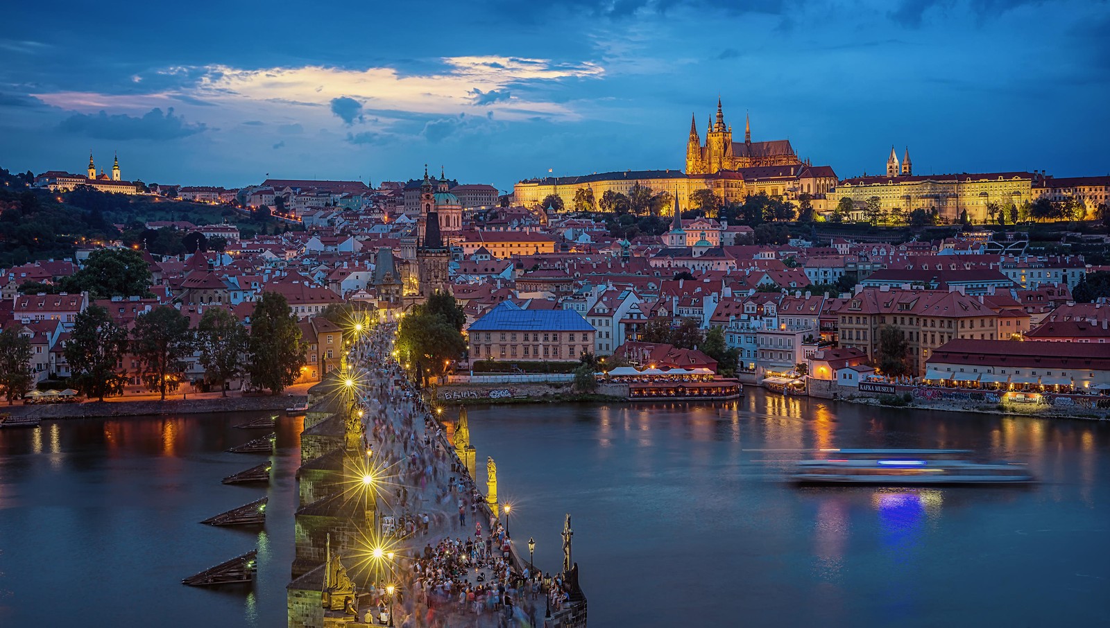 Eine arabische aussicht auf eine brücke mit einem boot auf dem wasser vor einer stadt (prag, fluss, stadt, wahrzeichen, stadtbild)