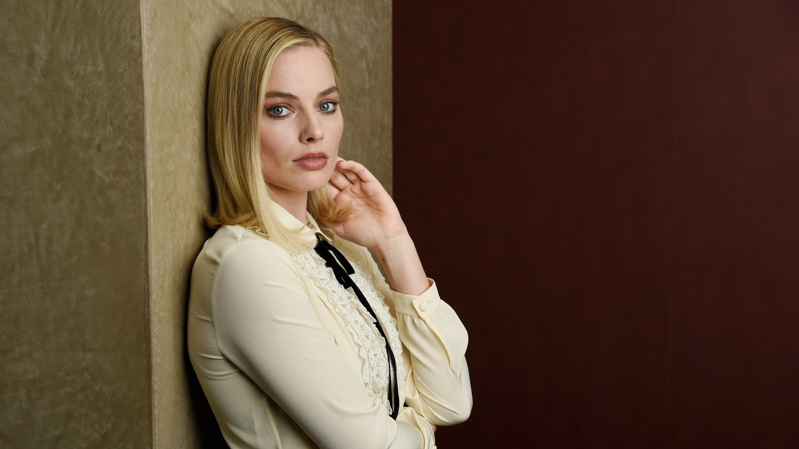 Mujer rubia apoyada contra la pared con la mano en la barbilla (margot robbie, sesión de fotos, actriz australiana, gente, fondo de pantalla 4k)