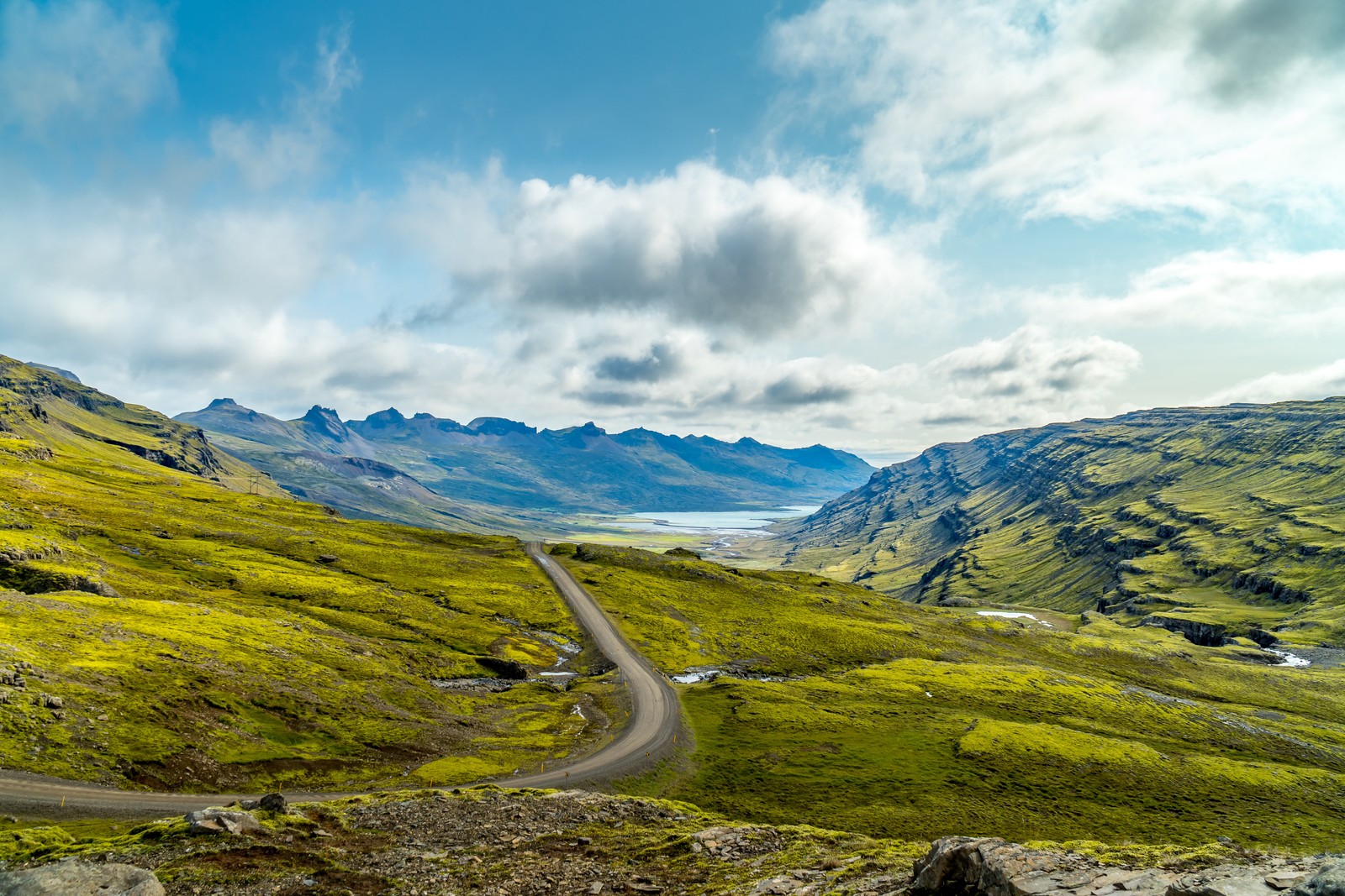 Una vista de una carretera sinuosa en las montañas con un lago a lo lejos (tierras altas, círculo dorado, viajar, turismo, nube)