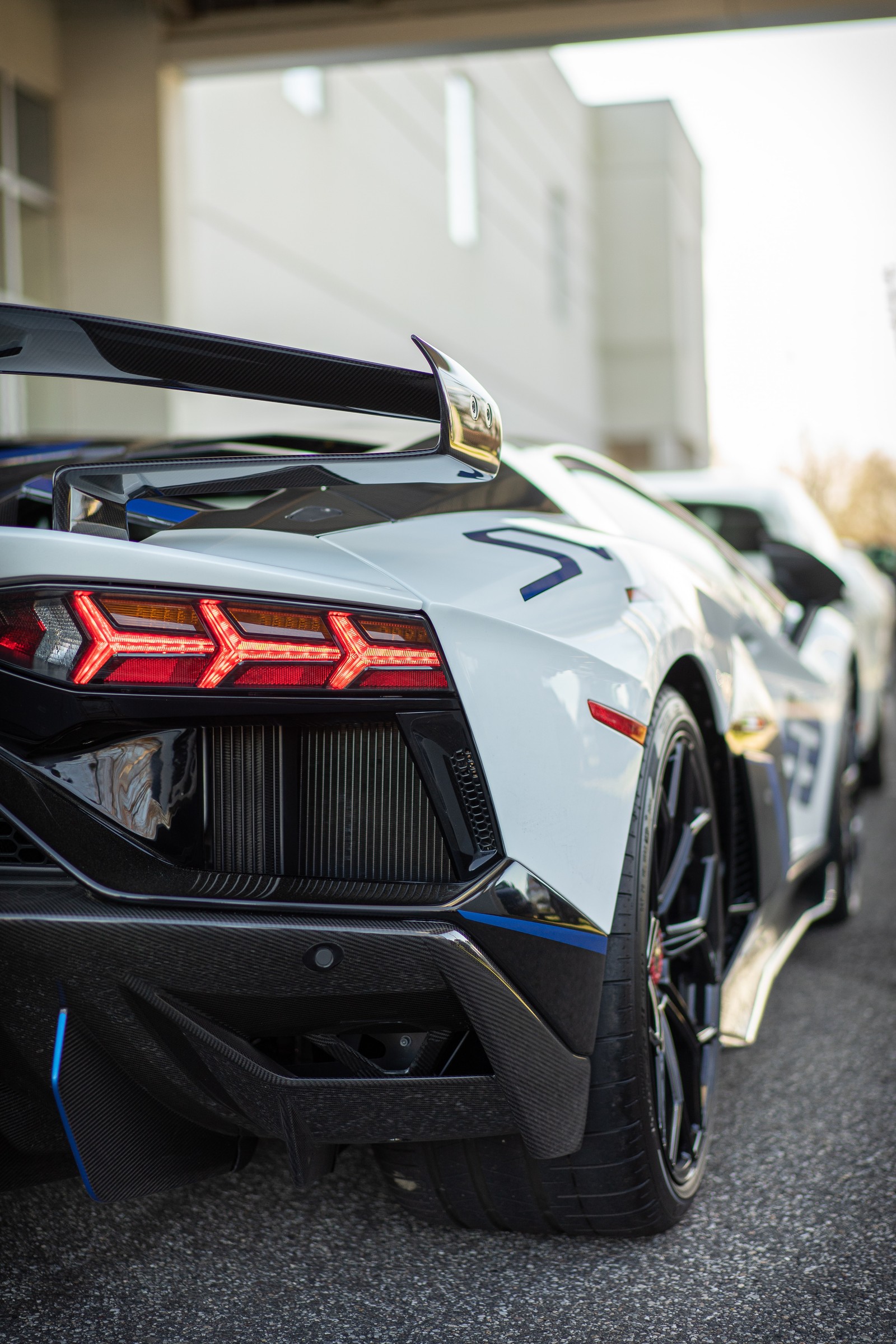 Um close em um carro esportivo branco estacionado em um estacionamento. (lamborghini, lamborghini aventador, lamborghini gallardo, carros, carro esportivo)