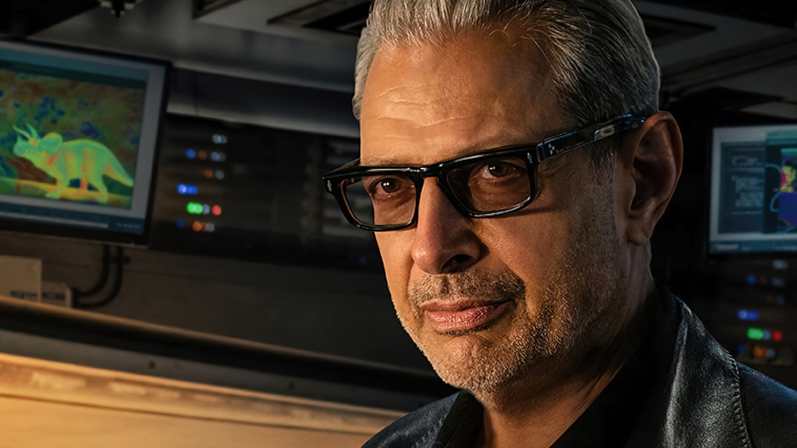 Un homme arabe portant des lunettes et une veste en cuir devant une télévision (jurassic world dominion, film, 2022, jeff goldblum, dr ian malcom)