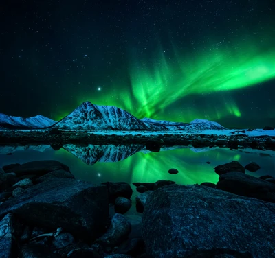 Aurora Borealis, die sich über einem Bergsee unter einem sternenklaren Nachthimmel spiegelt