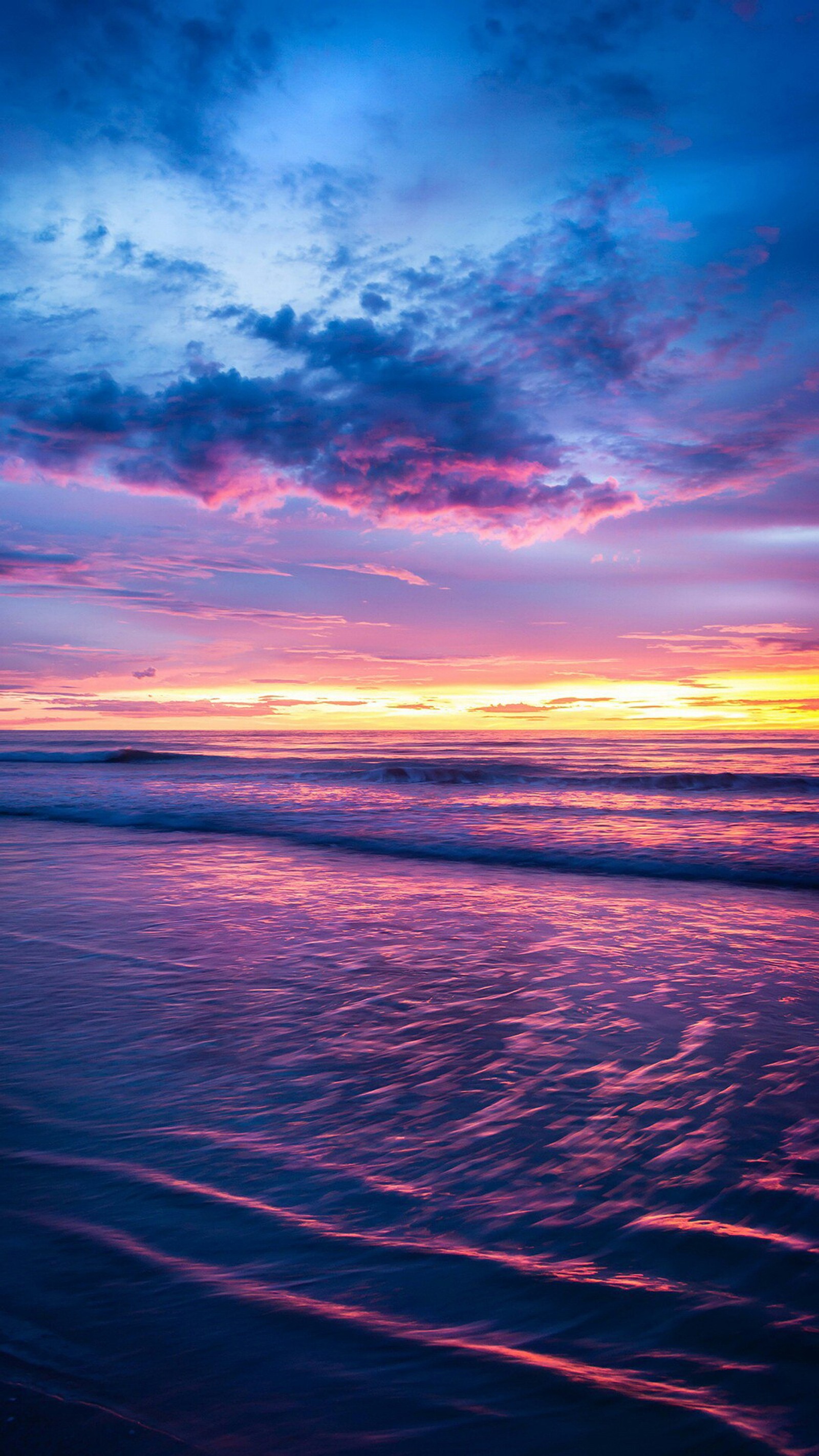 Coucher de soleil violet et bleu sur l'océan avec un surfeur sur la plage (horizon, eau, mer, nuage, atmosphère)