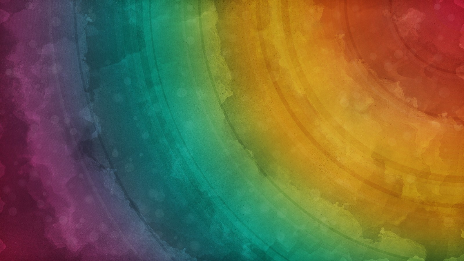 A close up of a rainbow colored background with a circular design (orange, green, yellow, acrylic paint, texture)