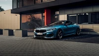 Coupé BMW 8 Series élégant garé avec élégance devant un bâtiment moderne, mettant en valeur son design frappant et ses caractéristiques de performance.