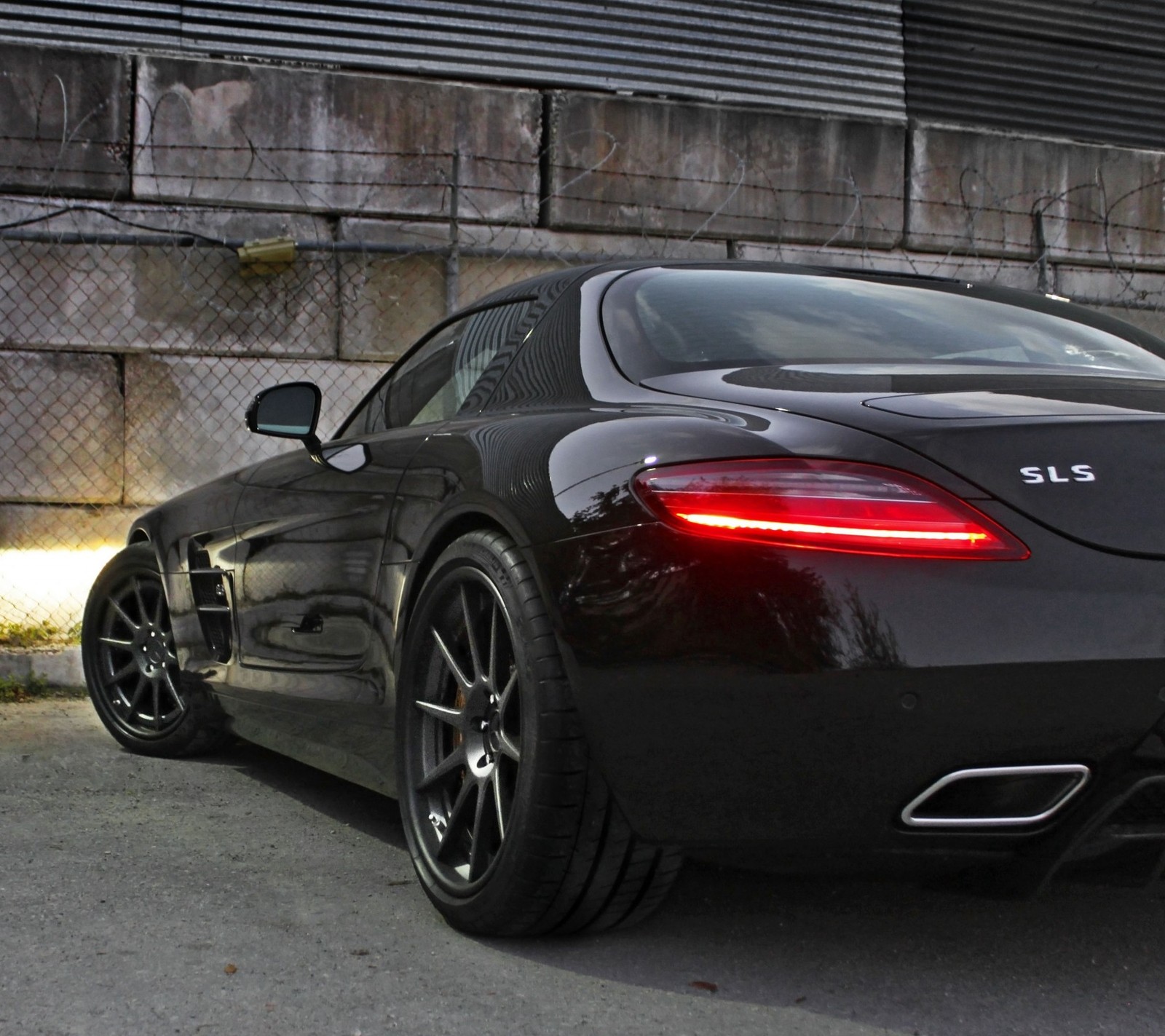 Um close de um carro esportivo preto estacionado na frente de um prédio (amg, benz, mercedes, sls)