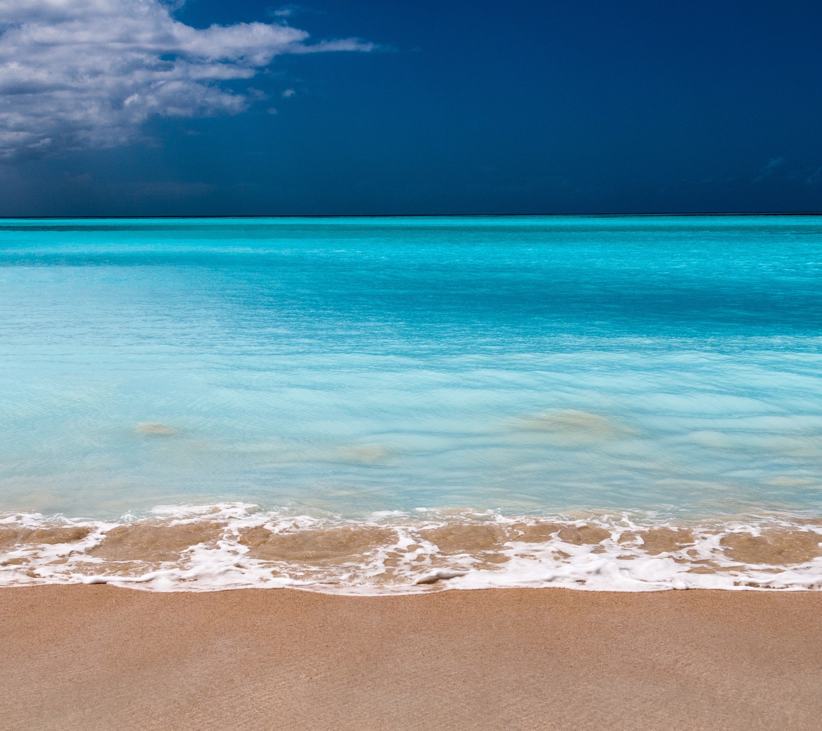 Toma aérea de una playa con cielo azul y agua (playa, azul, océano, arena, mar)