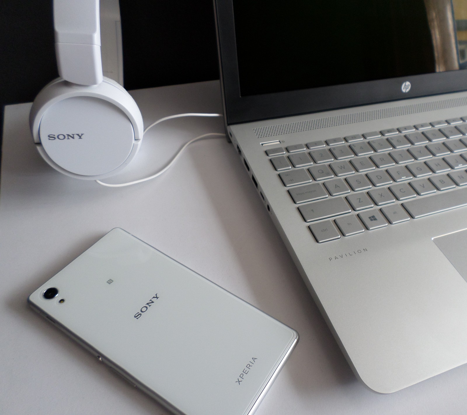 A close up of a laptop computer sitting on top of a white desk (hp, sony hp)