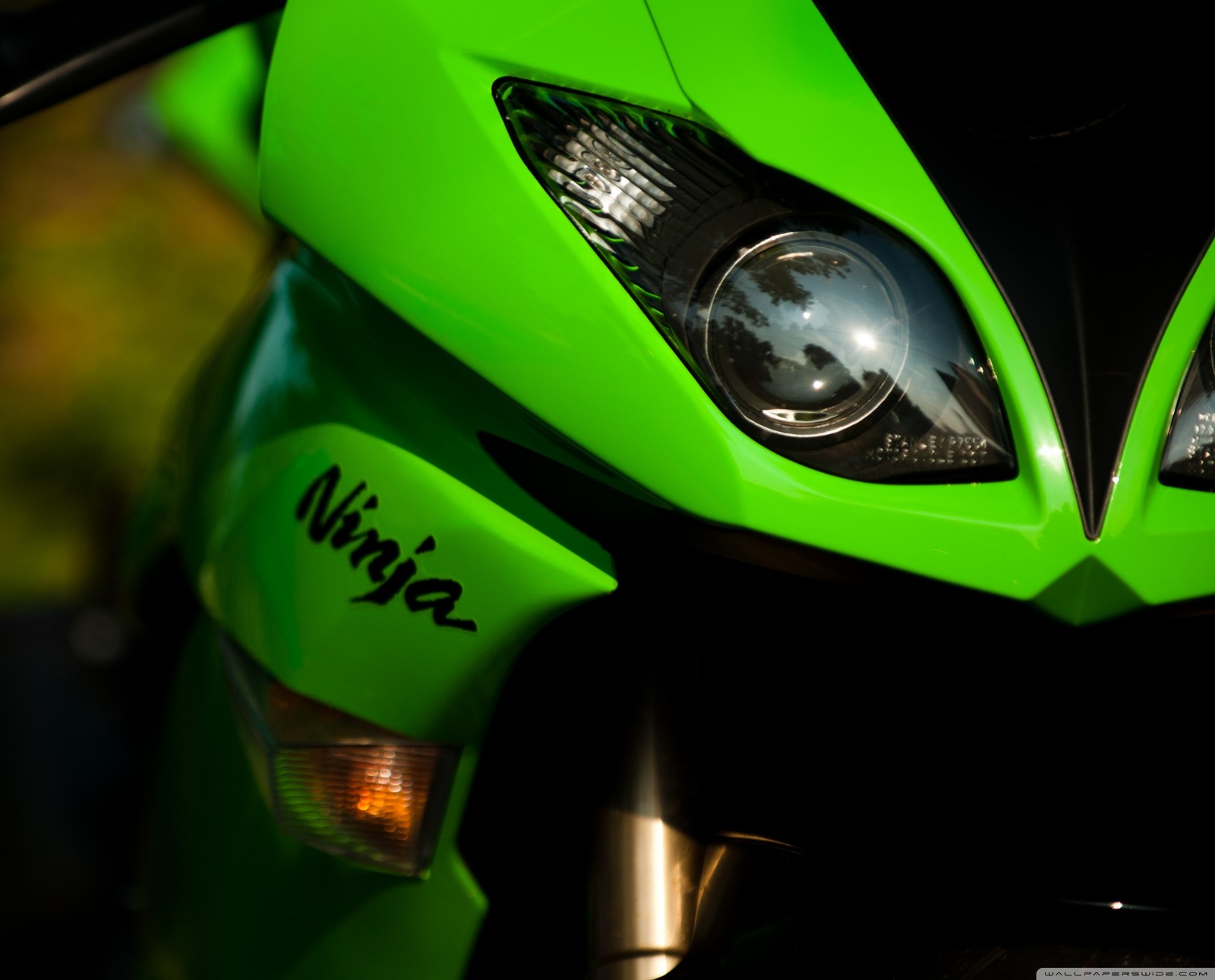 Un gros plan d'une moto verte avec un phare noir (vélo, hd, kawasaki, motos, ninja)