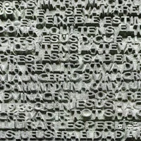 Textured stone surface with intricate carvings featuring words in multiple languages, set against a backdrop that suggests a connection to Barcelona's Sagrada Familia.