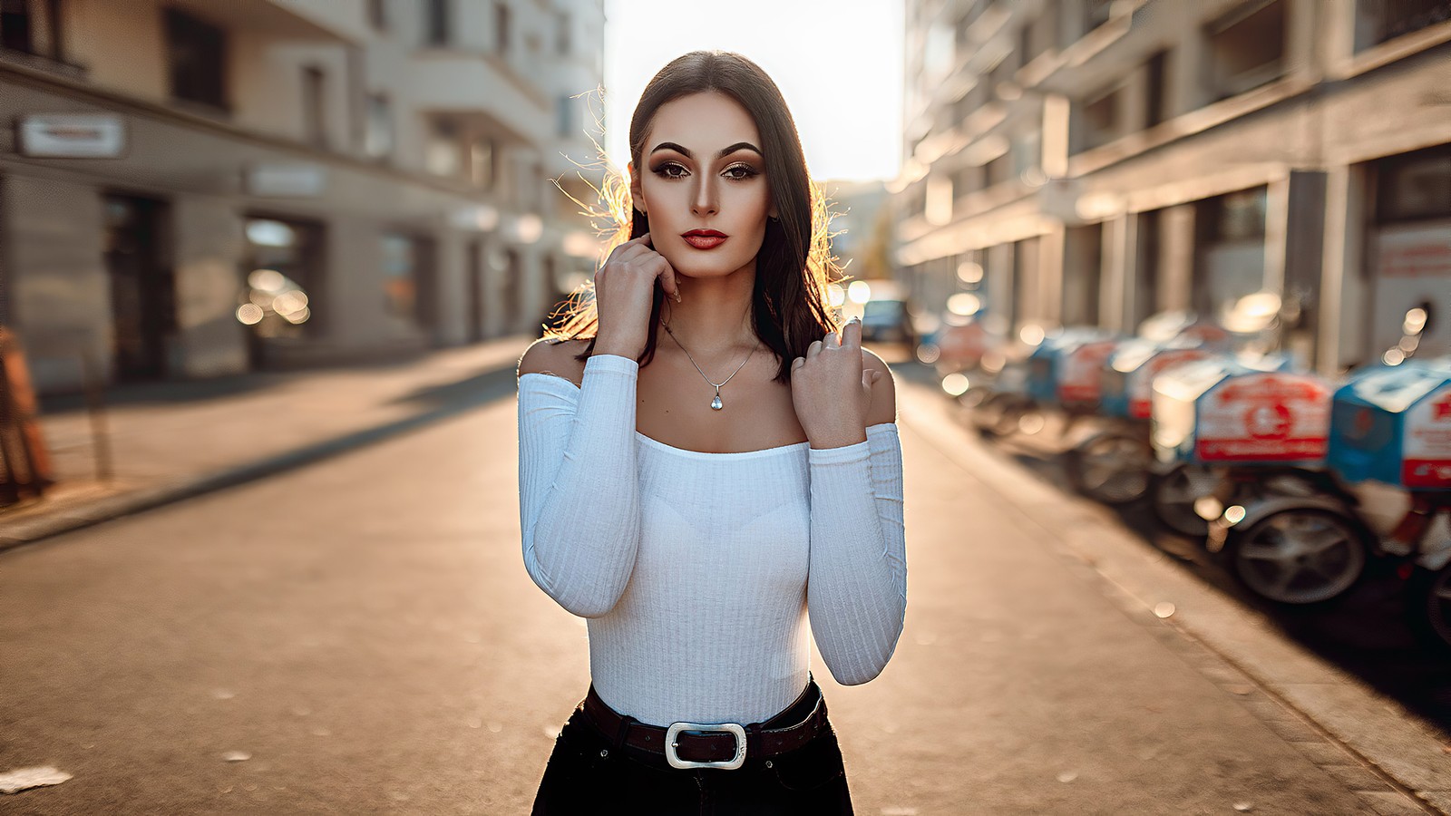 Une femme se tient dans la rue avec la main sur le visage (portrait, épaule, blanc, lèvre, mode de rue)