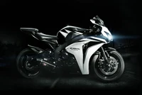 Elegante moto Honda CBR blanca con faro llamativo contra un fondo oscuro.