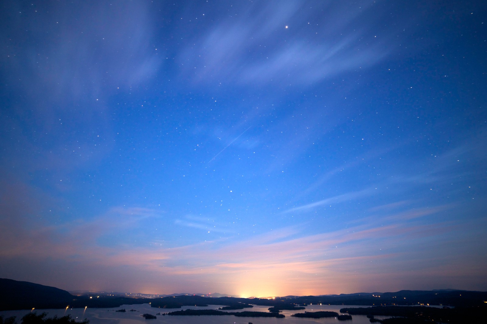 Vue d'un lac avec un ciel rempli d'étoiles et quelques bateaux (coucher de soleil, nuage, horizon, atmosphère, soir)