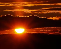 Golden Horizon: A Dramatic Sunset Glowing Behind Cumulus Clouds