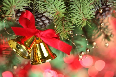 Campanas doradas adornadas con una cinta roja cuelgan de ramas perennes, rodeadas de luces bokeh festivas, capturando la esencia de la alegría navideña y las tradiciones de Navidad.