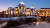 Ponte histórica iluminada e palácio à noite em uma metrópole de inverno