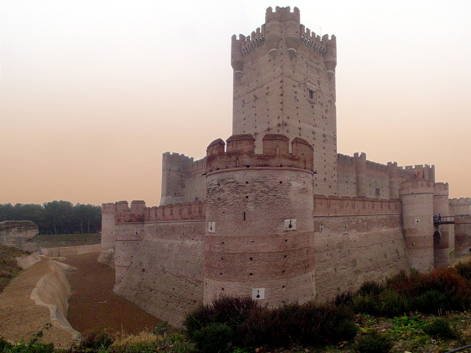 Hay un gran castillo con un reloj en la parte superior (castillo, fortificación, pared, sitio histórico, arquitectura medieval)