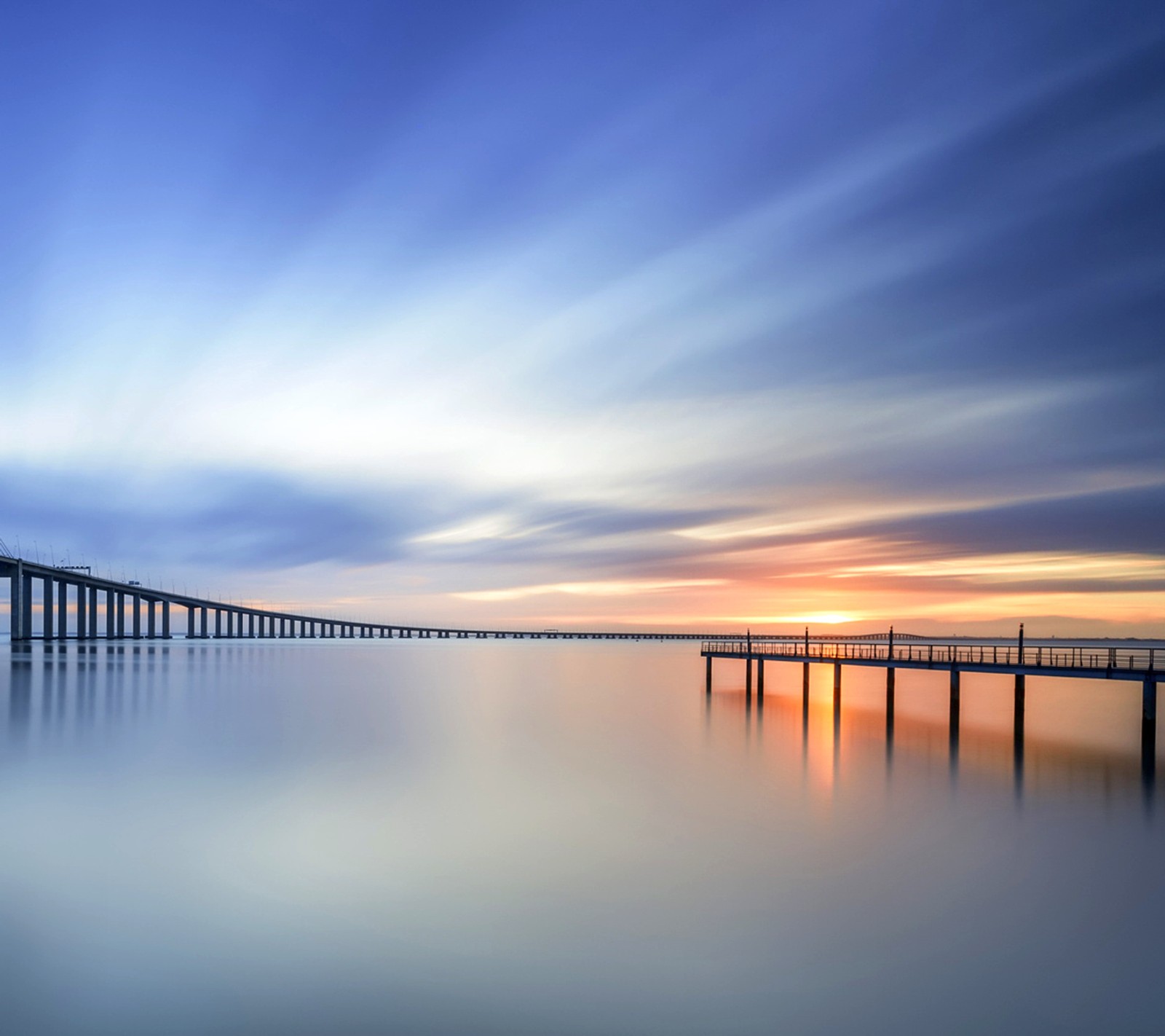 Vue aérienne d'un pont au-dessus d'un plan d'eau au coucher du soleil (réflexions, coucher de soleil)