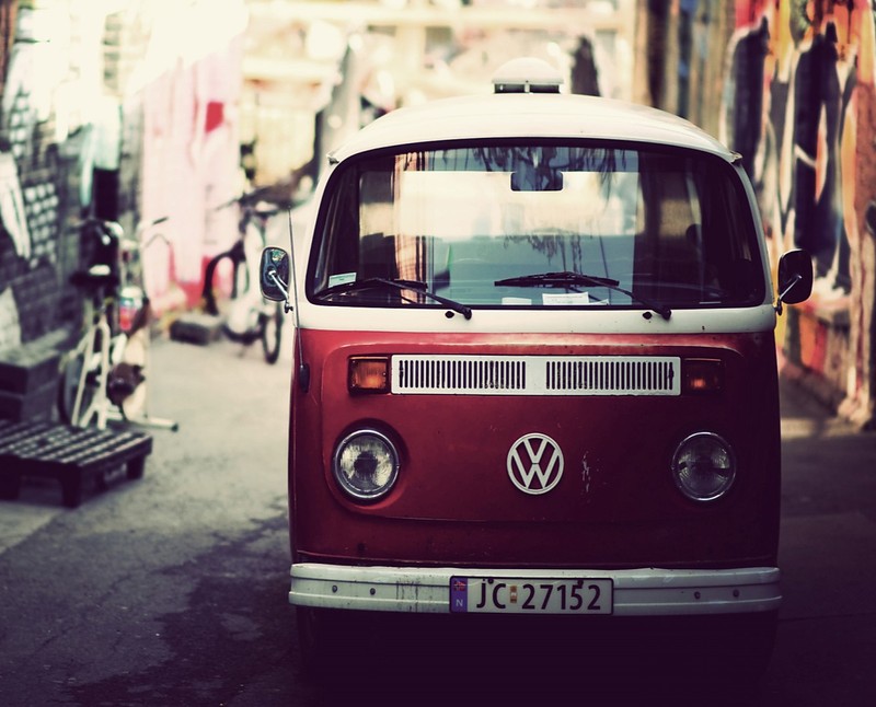 Hay una furgoneta roja y blanca estacionada al lado de la calle (coche, caravana, clásico, karavan, volkswagen)