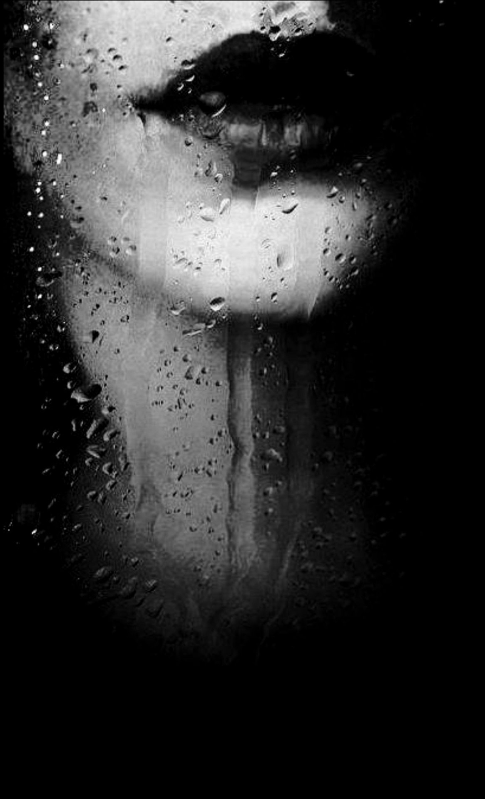 A black and white photo of a woman's face with water droplets on it (black and white, bw, lips, girl, rain)