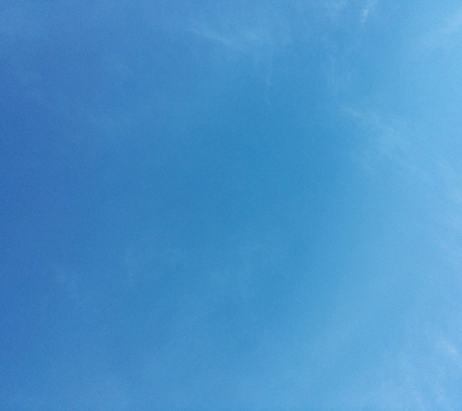 There is a plane flying in the sky with a blue sky in the background (blue, sky)