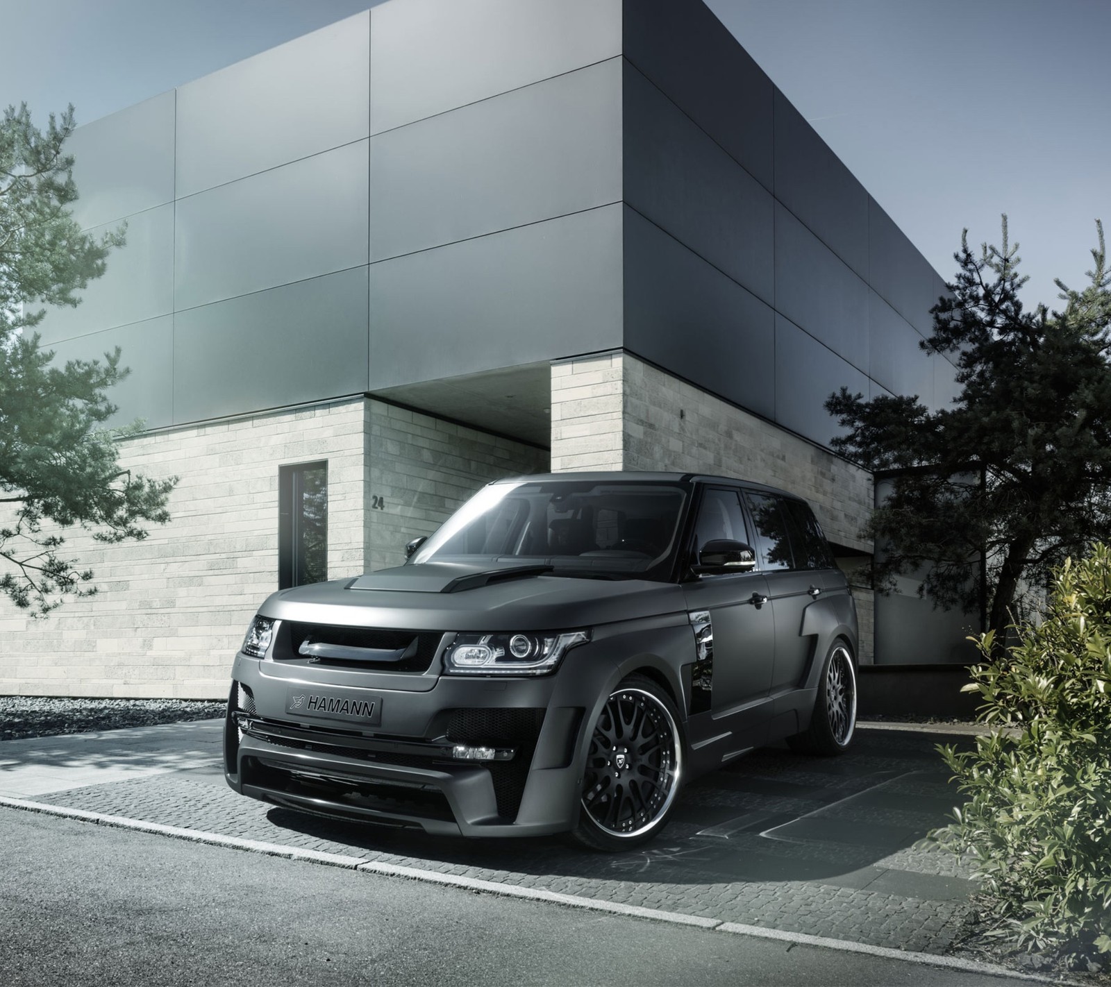 A black range rover parked in front of a building (auto, car, range rover)