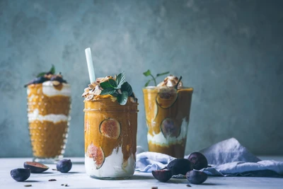 Délicieux desserts en couches avec du yaourt crémeux, des tranches de figue et des noix croquantes, joliment présentés dans des bocaux avec des garnitures de menthe.