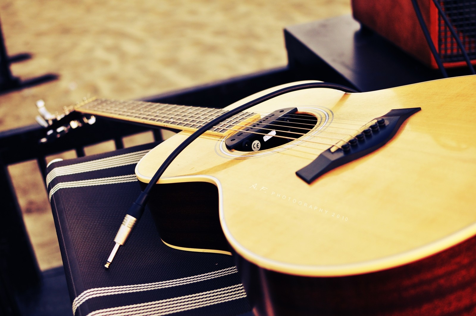 Une guitare et un support de guitare sur une table (guitare, instrument à cordes, guitare acoustique, instrument de musique, instruments à cordes pincées)