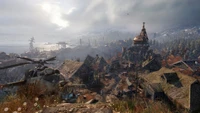 Paysage post-apocalyptique dans Metro Exodus, présentant une ville désolée avec un hélicoptère en ruine et des montagnes lointaines sous un ciel dramatique.