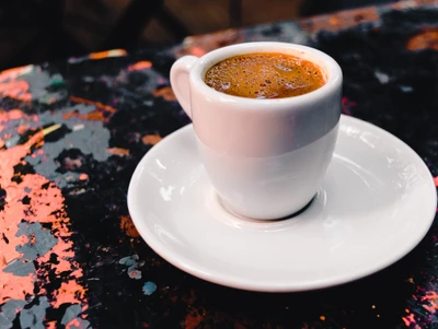 Espresso fumegante em uma xícara branca em uma mesa colorida