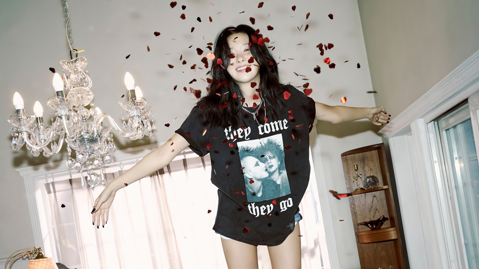 Una mujer árabe con una camisa negra y lápiz labial rojo de pie en una habitación (seulgi, 슬기, kang seul gi, 강슬기, red velvet)