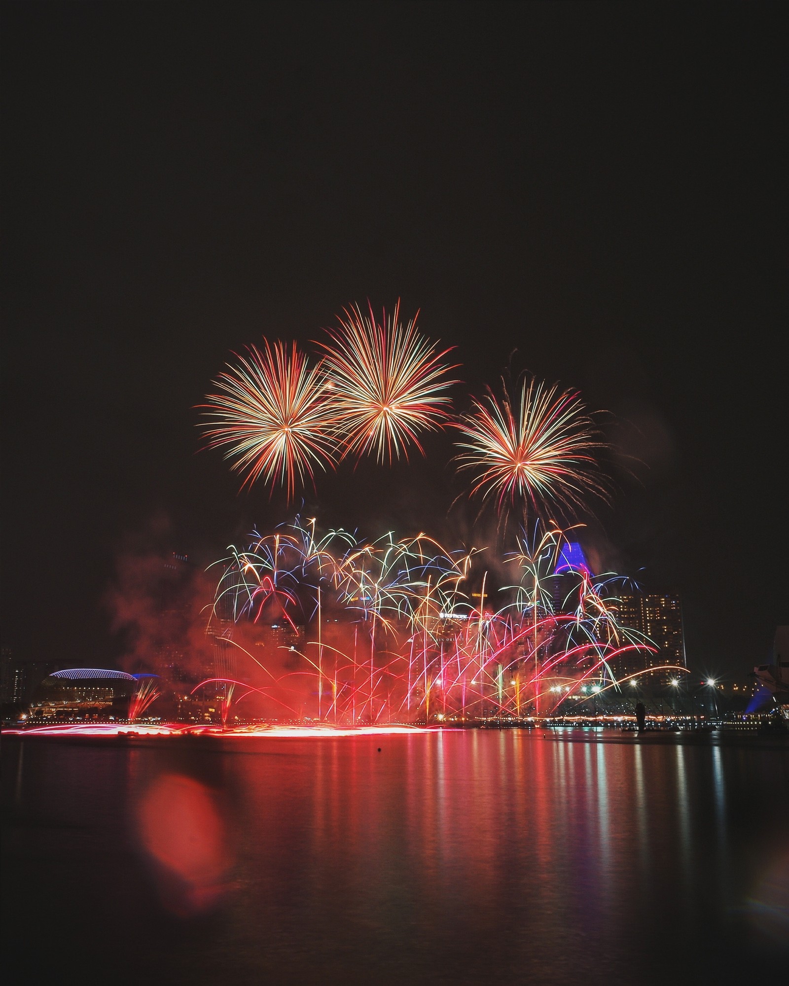 Des feux d'artifice illuminent le ciel au-dessus d'une ville la nuit (nouvel an, feux dartifice, nuit, jour de lan, minuit)