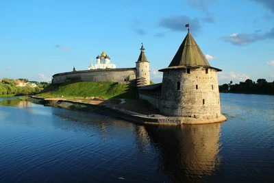 Un majestueux château médiéval entouré d'eaux sereines, avec une tour fortifiée et un fossé réfléchissant, sous un ciel bleu éclatant.