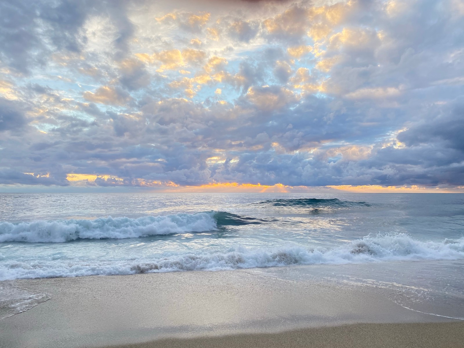 Vue aérienne d'une plage avec des vagues et un ciel nuageux (mer, eau, nuage, crépuscule, environnement naturel)