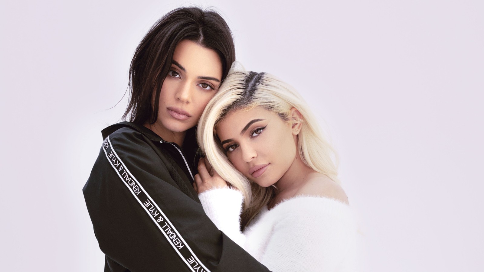 Dos mujeres en atuendos en blanco y negro posando para una foto (hermanas jenner, jenner sisters, kendall jenner, kylie jenner, gente)