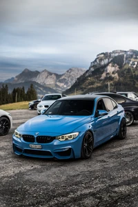 BMW M3 em azul marcante, estacionado contra um fundo montanhoso dramático, exibindo seu design esportivo e apelo de luxo.