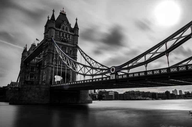 Черно-белое фото моста с лодкой на воде (tower bridge, мост, достопримечательность, монохром, небо)