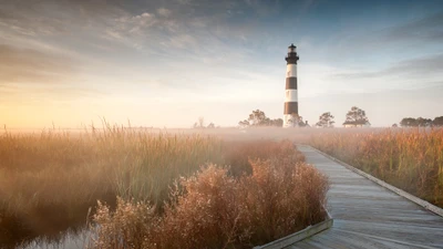 Lumière du matin au phare : Un phare serein au milieu des herbes de prairie