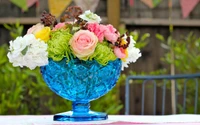 Lebendige Blumenarrangement in einer blauen Kristallvase