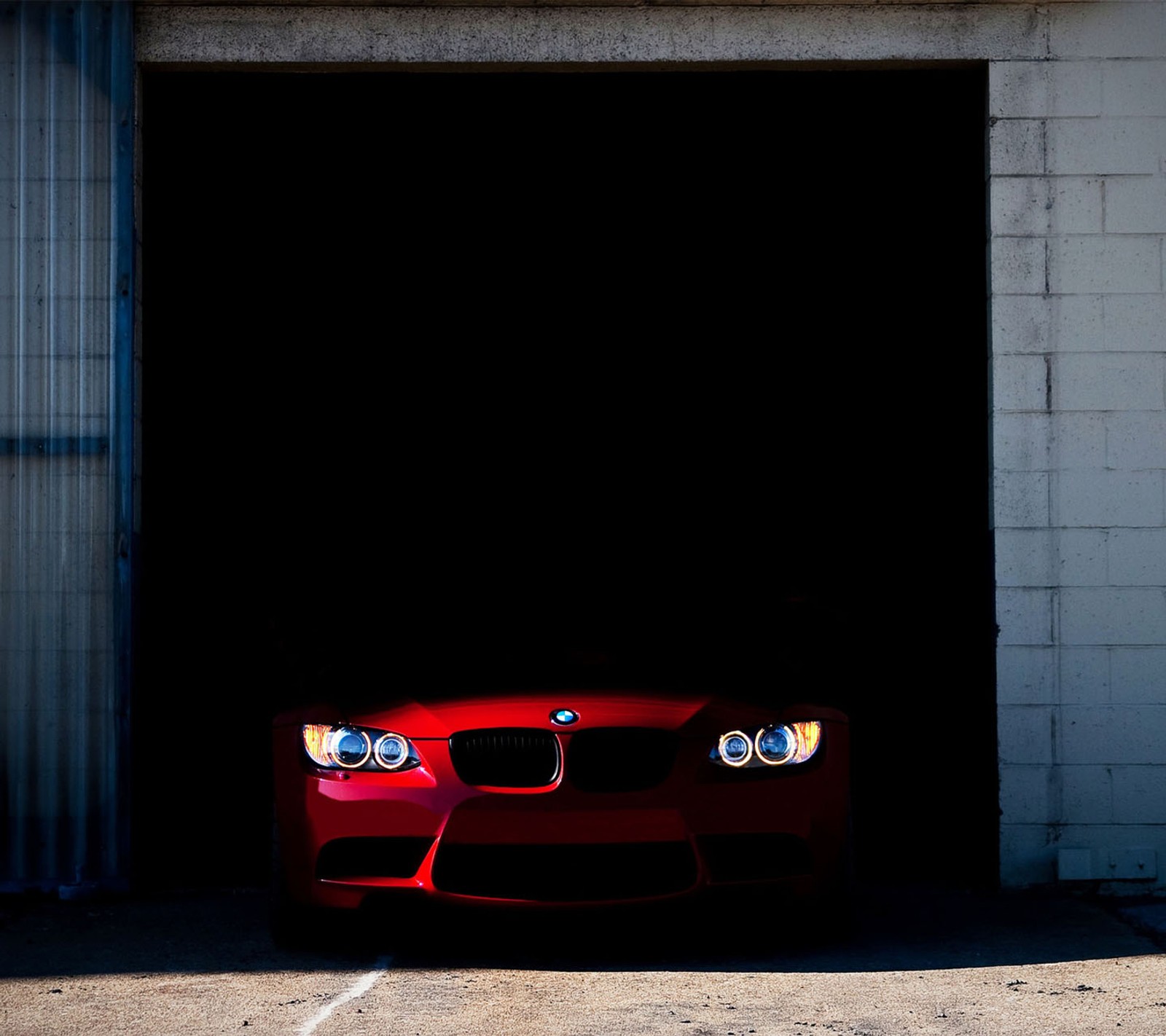 A close up of a red car parked in front of a garage (bmw, red)