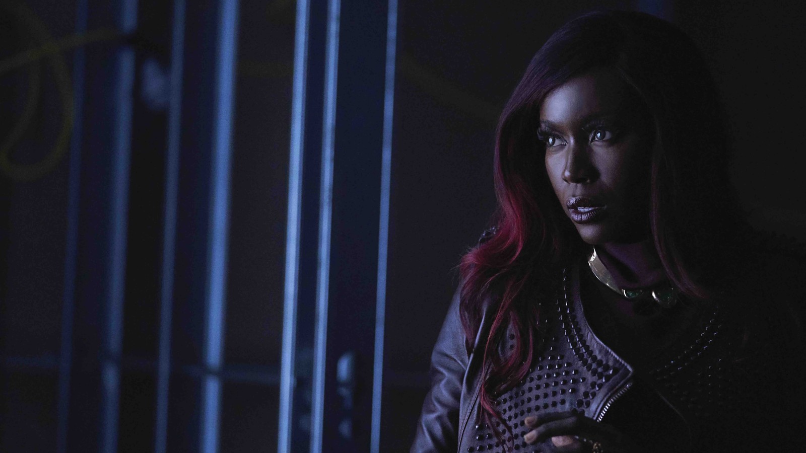 Une femme aux cheveux rouges et en veste noire se tenant dans une pièce sombre (starfire, kory anders, titans, saison 2, série télévisée)