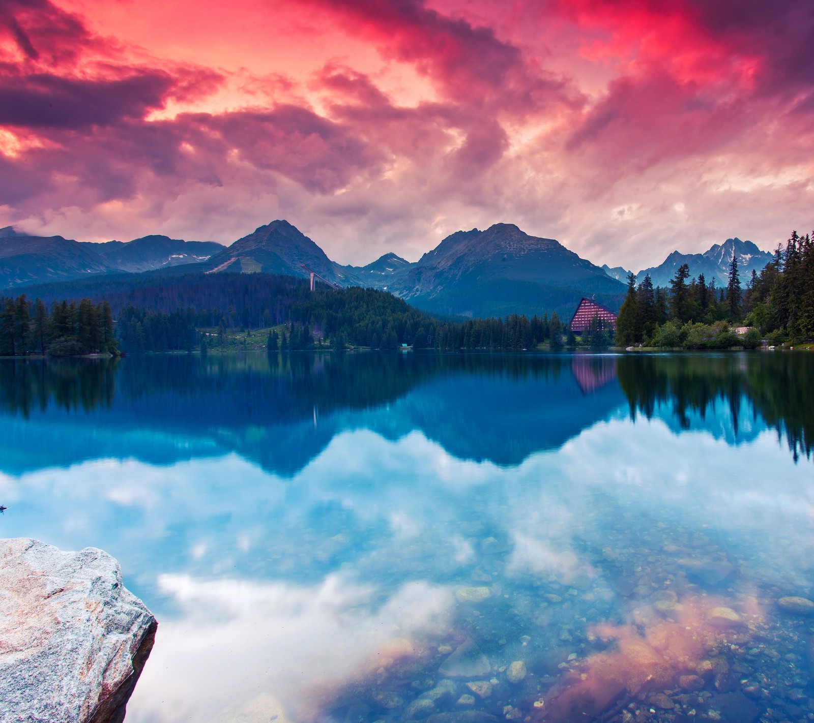 A view of a lake with a mountain in the background (cabin, lake, mountain, sky, sunset)