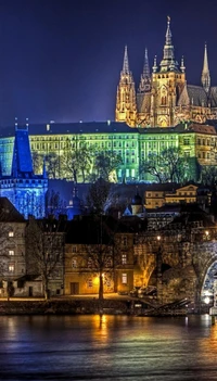 Beleuchtete Prager Burg mit Blick auf die Moldau bei Nacht