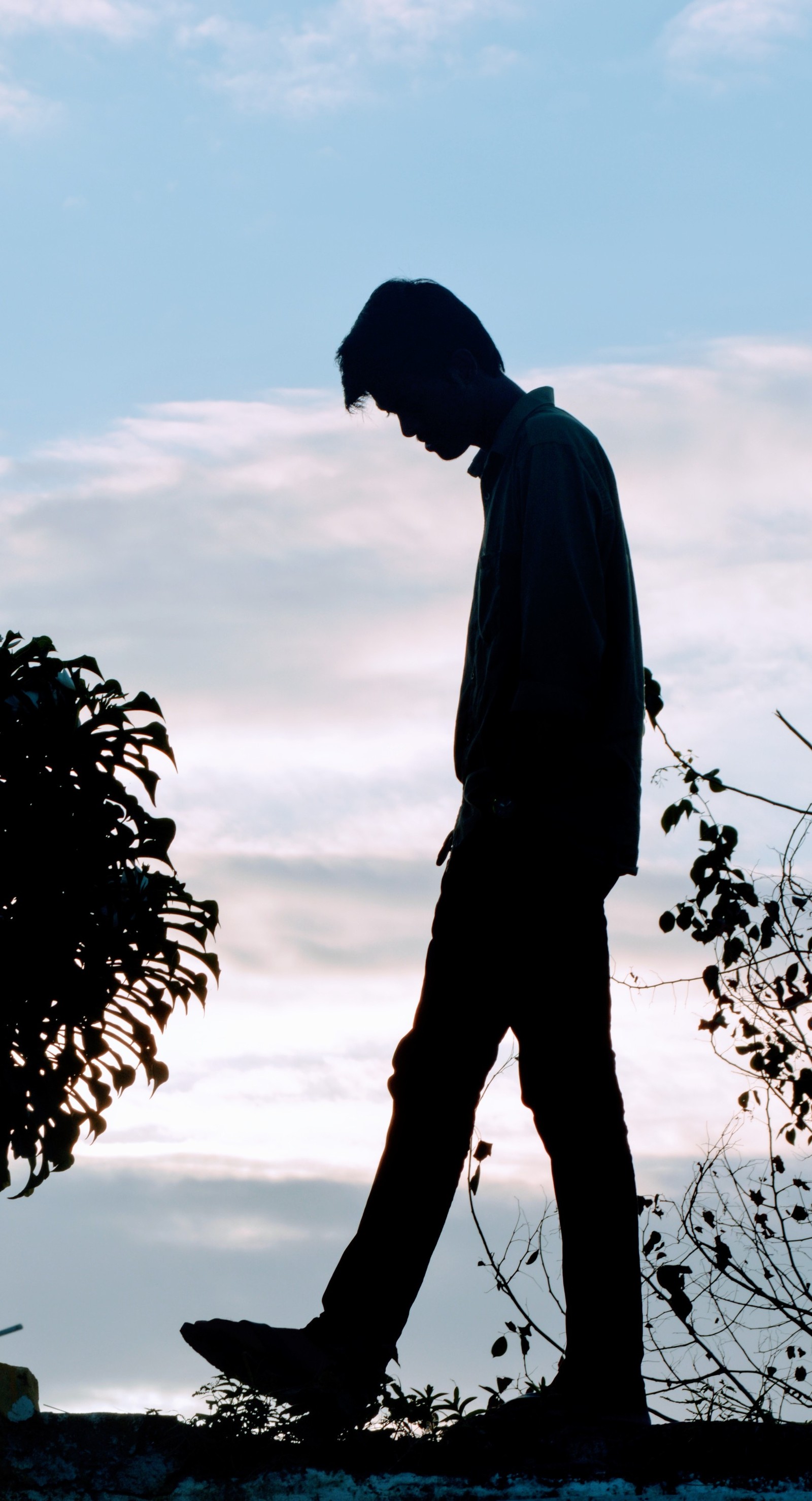 Silhouette d'un homme marchant le soir avec un skateboard (seul, attitude, vie, solitaire, triste)